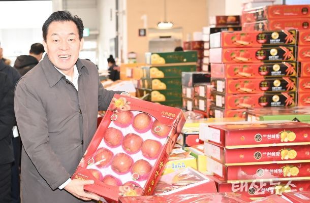 수원시 농수산물도매시장을 방문한 이재준 시장이 사과 상자를 들어보고 있다.