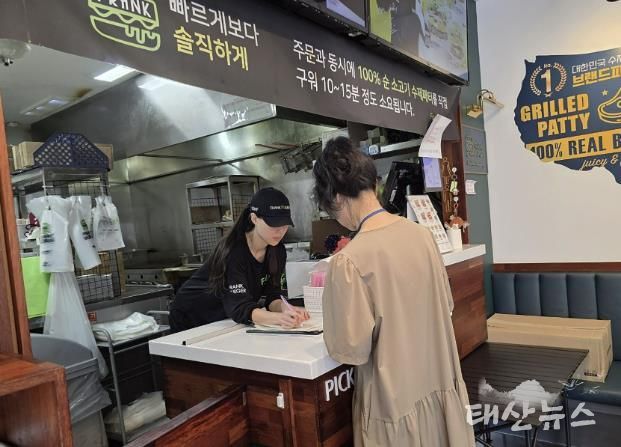 성남시 어린이 기호식품 전담관리원이 지난 9월 학교 주변 햄버거 판매점에서 영업자와 종업원의 건강진단 실시 여부를 점검하고 있다